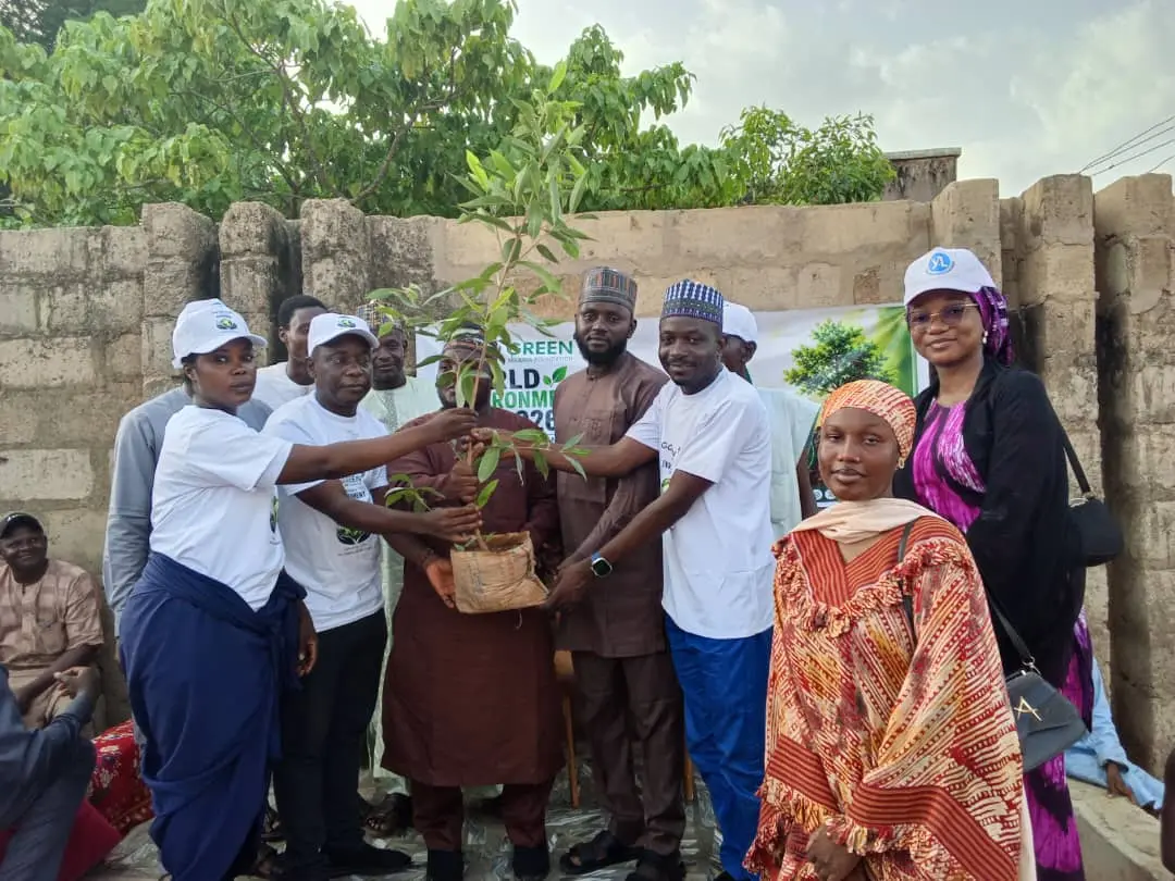 Volunteers and community members holding a seedling ready for planting